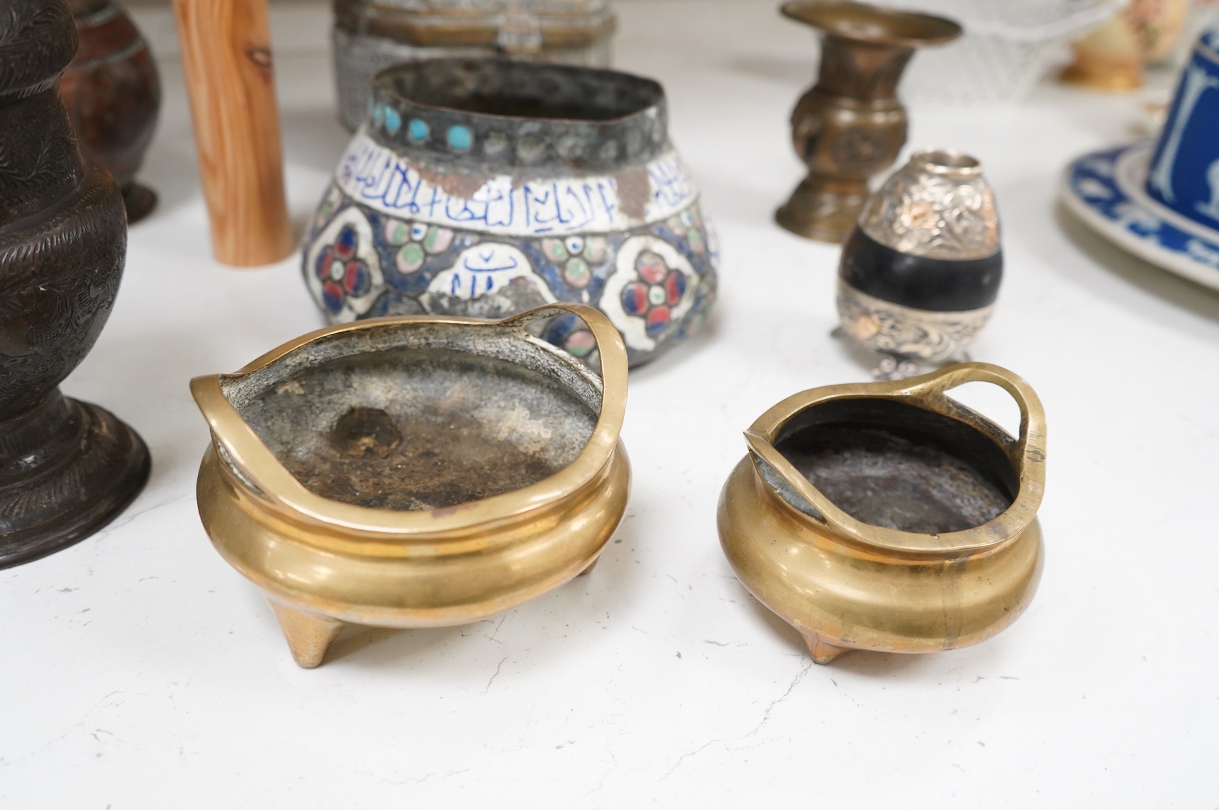 A collection of Persian, Eastern and Chinese metalware to include two brass tripod censers, pair of vases and an enamel bowl, largest 33cm high